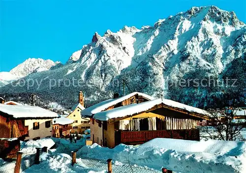 AK / Ansichtskarte Mittenwald_Bayern Ortsmotiv mit Kirche gegen Karwendelgebirge Winterpanorama Mittenwald Bayern