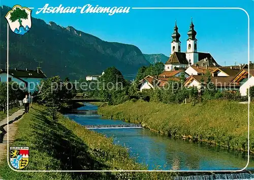 AK / Ansichtskarte Aschau_Chiemgau Uferpartie am Fluss Blick zur Kirche Chiemgauer Alpen Aschau Chiemgau