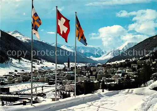 AK / Ansichtskarte Davos_Platz_GR Gesamtansicht mit Alpenpanorama im Winter Fahnen Davos_Platz_GR