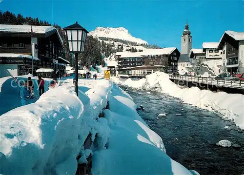 AK / Ansichtskarte Lech_Vorarlberg Partie am Fluss im Winter Kirche Blick gegen Karhorn Alpen Lech Vorarlberg