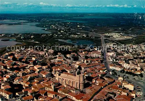 AK / Ansichtskarte Les_Saintes Maries de la Mer Le village et l Eglise blottis au milieu des marais vue aerienne Les