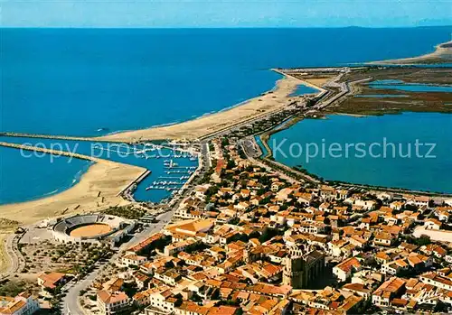 AK / Ansichtskarte Les_Saintes Maries de la Mer Vue aerienne de la ville Les arenes et le port Eglise fortifiee Les