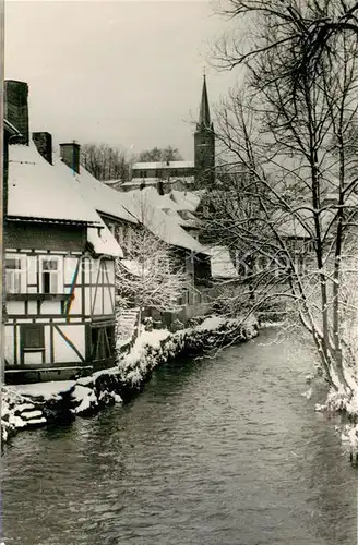 AK / Ansichtskarte Bad_Berleburg Haeuserpartie an der Odeborn Blick zur Kirche im Winter Bad_Berleburg
