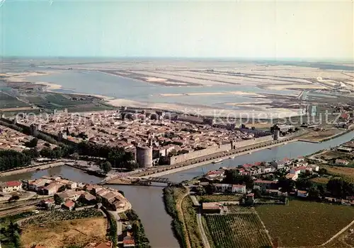 AK / Ansichtskarte Aigues Mortes_Gard Vue aerienne sur la Cite de Saint Louis dans le fond les Marais Salants Aigues Mortes Gard