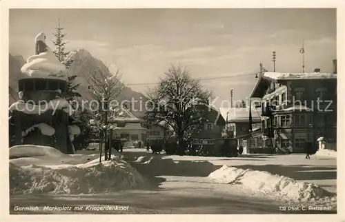 AK / Ansichtskarte Garmisch Partenkirchen Marktplatz mit Kriegerdenkmal im Winter Garmisch Partenkirchen