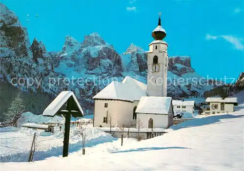 AK / Ansichtskarte Colfosco gegen Sellagruppe Dolomiten Motiv mit Kirche Winterlandschaft Colfosco