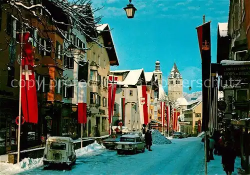 AK / Ansichtskarte Kitzbuehel_Tirol Innenstadt Fahnen im Winter Wintersportplatz Alpen Kitzbuehel Tirol
