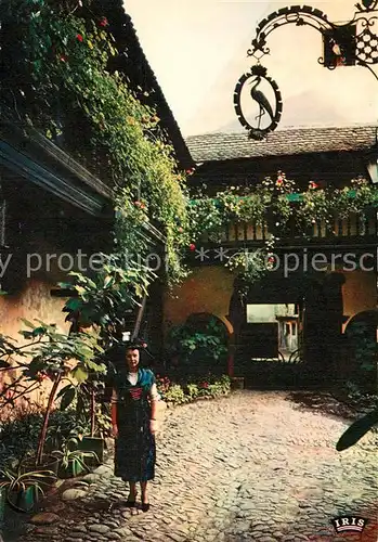 AK / Ansichtskarte Riquewihr_Haut_Rhin Alsacienne dans la cour des Cigognes Riquewihr_Haut_Rhin