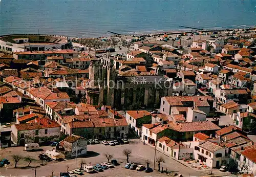 AK / Ansichtskarte Les_Saintes Maries de la Mer Vue aerienne de lEglise fortiefiee les Arenes et la Plage Les