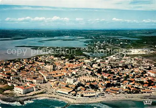 AK / Ansichtskarte Saintes Maries de la Mer Vue aerienne du village Eglise Etang des Launes Saintes Maries de la Mer