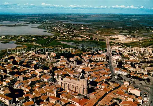 AK / Ansichtskarte Les_Saintes Maries de la Mer Village et l eglise blottis au millieu des marais vue aerienne Les