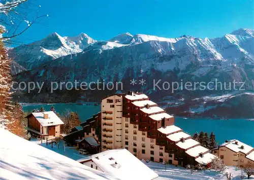 AK / Ansichtskarte Beatenberg Dorint Aparthotel Bluemlisalp mit Eiger Moench und Jungfrau Berner Alpen Thunersee Winterpanorama Beatenberg