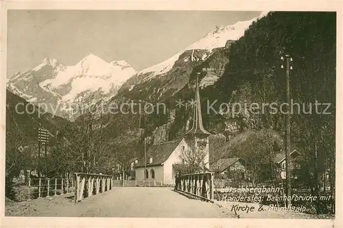 AK / Ansichtskarte Kandersteg_BE Loetschbergbahn Bahnhofbruecke mit Kirche und Bluemlisalp Kandersteg_BE