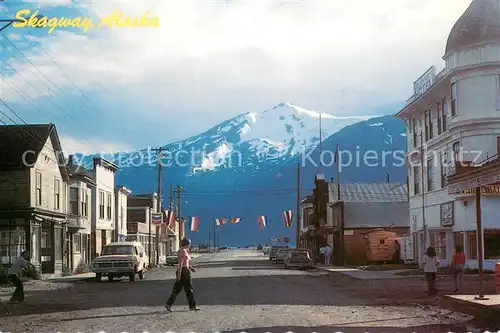 AK / Ansichtskarte Skagway_Alaska Old buildings line Broadway Mountains 