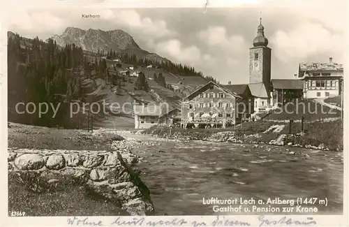 AK / Ansichtskarte 73807660 Lech_Vorarlberg Uferpartie am Fluss Blick auf Gasthof Pension zur Krone und Kirche Lech Vorarlberg