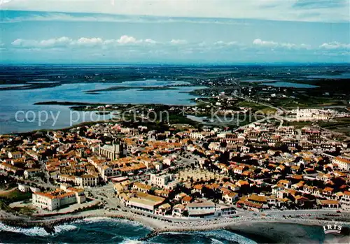 AK / Ansichtskarte Stes Maries de la Mer Vue aerienne du village lEglise et lEtang des Launes 