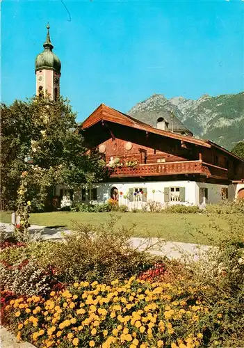 AK / Ansichtskarte 73885557 Garmisch-Partenkirchen Pfarrkirche mit altem Bauernhaus Garmisch-Partenkirchen