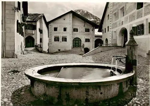 AK / Ansichtskarte  Guarda_GR Dorfplatz mit Brunnen