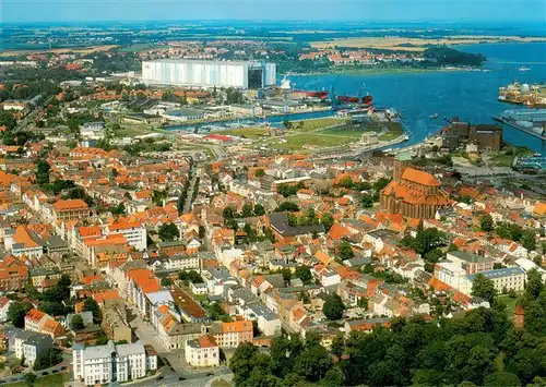 AK / Ansichtskarte 73956317 Wismar_Mecklenburg Altstadtblick mit Marienkirchturm Nikolaikirche und Hafen mit der Schiffsbauhalle der Werft