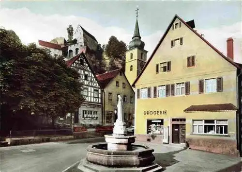 AK / Ansichtskarte 73975747 Pottenstein_Oberfranken Ortszentrum Brunnen Drogerie Kirchturm