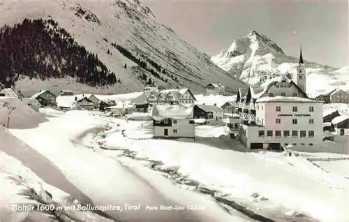 AK / Ansichtskarte 73976459 Galtuer_Tirol_AT Ortsansicht mit Kirche Winterpanorama mit Ballunspitze Alpen