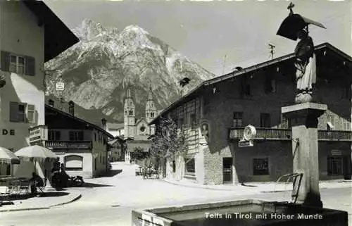 AK / Ansichtskarte 73981825 Telfs_Tirol_AT Ortszentrum Brunnen Blick zur Kirche Hohe Munde