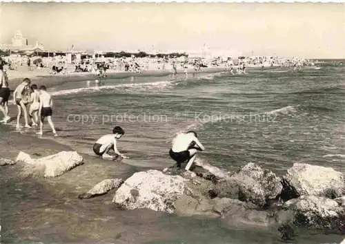AK / Ansichtskarte  LES SAINTES-MARIES-DE-LA-MER 13 Bouches-du-Rhone La grande plage au fond les arènes et l'église fortifiée