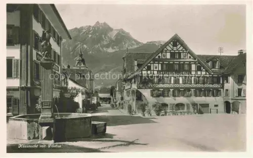 AK / Ansichtskarte KuessNACHT Vierwaldstaettersee SZ Motiv Ortszentrum Brunnen Gasthaus zum Engel Blick gegen Pilatus