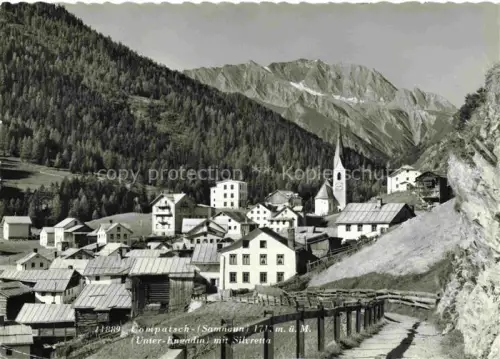 AK / Ansichtskarte Compatsch Kompatsch Samnaun Dorf GR Ansicht mit Kirche Blick gegen Silvretta