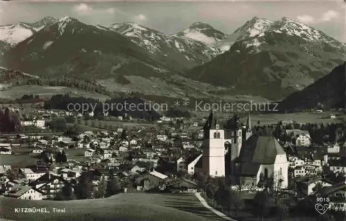 AK / Ansichtskarte Kitzbuehel Tirol AT Kirche Alpen Schnee Daecher Wiese
