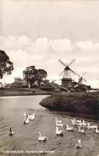 AK / Ansichtskarte Greetsiel Krummhoern Aurich Niedersachsen Windmuehlen Kanal Gaense Haeuser Baeume
