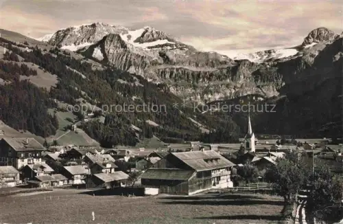 AK / Ansichtskarte Lenk Simmental BE Ortsansicht mit Kirche Blick gegen Wildstrubel Raezligletscher Gletscherhorn Berner Alpen