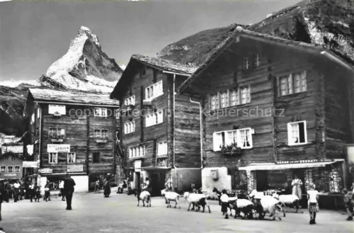 AK / Ansichtskarte ZERMATT VS Dorfstrasse Matterhorn Holzchalets Bazar Ziegenherde Dorfplatz Berge