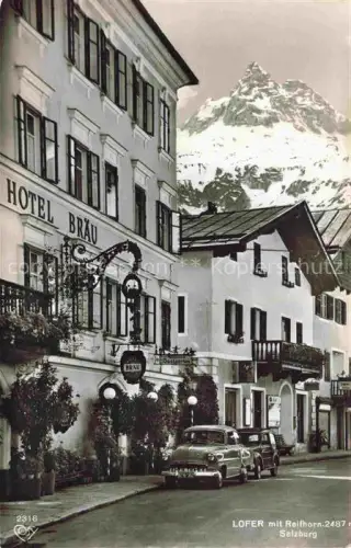 AK / Ansichtskarte Lofer Pinzgau-Pongau AT Hotel-Braeu Reifhorn Hauptstrasse Bergdorf Alpen Autos Schneeberge