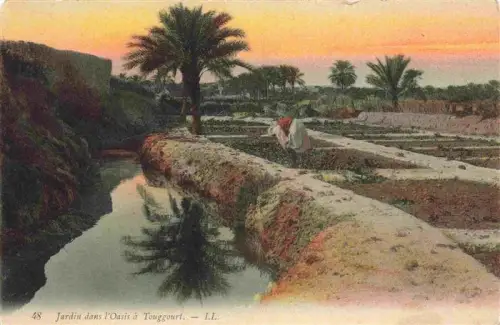 AK / Ansichtskarte Touggourt Tougourt Algerie Oasis Bewaesserungskanal Palmen Garten Feldbauer Sonnenuntergang