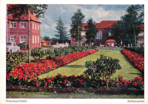 AK / Ansichtskarte Wiesmoor Aurich Niedersachsen Rathausplatz Blumenbeete Rasenflaeche Backsteingebaeude Baeume Autos Park
