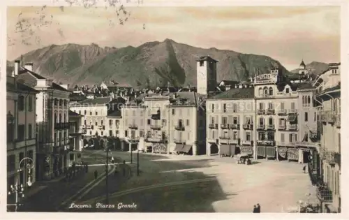 AK / Ansichtskarte LOCARNO Lago Maggiore TI Piazza-Grande Turm Geschaefte Strassenszene Berge Tramgleise