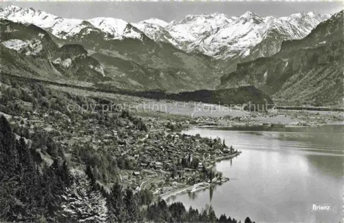 AK / Ansichtskarte Brienz Brienzersee BE Brienzersee See Dorf Berge Schnee Wald Vogelperspektive