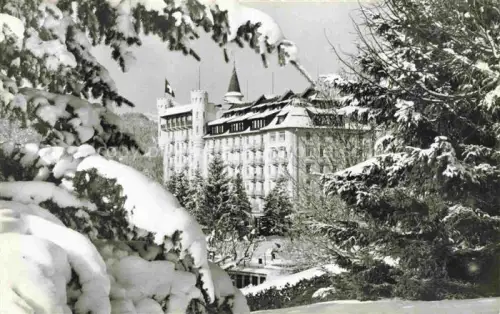 AK / Ansichtskarte Gstaad Saanen BE Palace-Hotel Hotel Schloss Schnee Tannen Winter Schweizer-Fahne