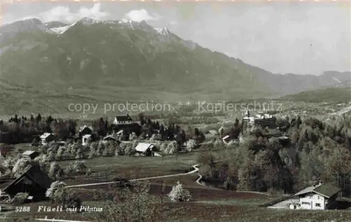 AK / Ansichtskarte Flueeli-Ranft Fluehli-Ranft OW Pilatus Bergpanorama Dorf Wiesen Baeume Kapelle Hotel Kirchturm