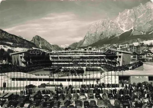 AK / Ansichtskarte Cortina d Ampezzo Veneto IT Stadio-Olimpico-del-Ghiaccio Eisstadion Olympiade-1956 Dolomiten Winter Zuschauer Flaggen Parkplatz