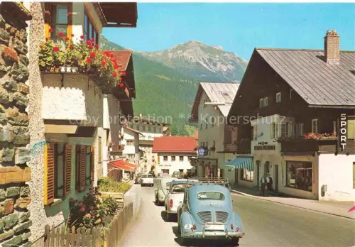 AK / Ansichtskarte St Anton Arlberg Tirol AT Dorfstrasse Sport-Geschaeft Berge Geranien Autos Alpenarchitektur Arlberg