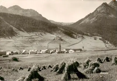 AK / Ansichtskarte Montgenevre Mont-Genevre 05 Hautes-Alpes Les-Gondrans Dorf Kirchturm Alpen Bergtal Nadelwald Heugarben Felder