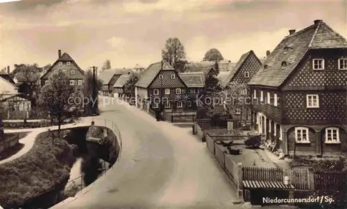 AK / Ansichtskarte Niedercunnersdorf Goerlitz Sachsen Dorfstrasse Umgebindehaeuser Fachwerkhaeuser Bach Bruecke Oberlausitz