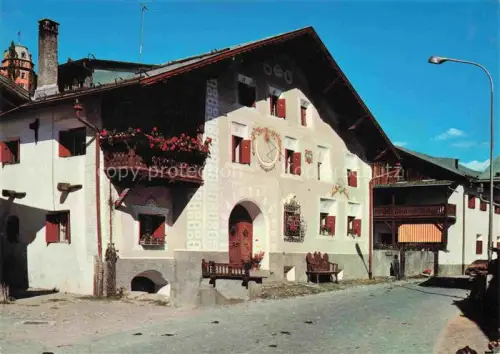 AK / Ansichtskarte Scuol Schuls GR Engadinerhaus Sgraffito Sonnenuhr Blumen Dorfstrasse Unterengadin