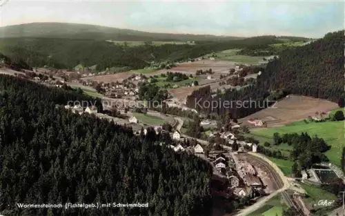 AK / Ansichtskarte Warmensteinach Fichtelgebirge Schwimmbad Fliegeraufnahme Wald Dorf Wiesen Felder