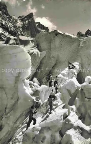 AK / Ansichtskarte Grindelwald BE Eisgrotte Gletscher Schweizer-Flagge Bergsteiger Gletscherspalten Schnee Fels