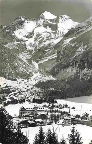 AK / Ansichtskarte Kandersteg BE Bluemlisalp Bergdorf Winter Schnee Haeuser Wald Berge