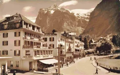 AK / Ansichtskarte Grindelwald BE Dorfstrasse Wetterhorn Hotel-Kreuz Passanten Berge Strasse