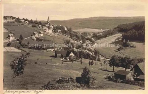 AK / Ansichtskarte Johanngeorgenstadt Erzgebirgskreis Sachsen Stadtpanorama Erzgebirge Kirchturm Wohnhaeuser Bergwiesen Talbild